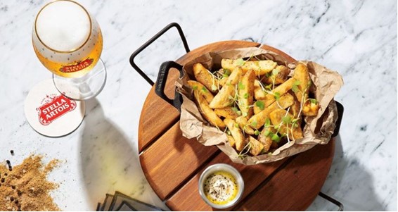 Image of Garnished Fries with dip and a glass of Stella Artois
